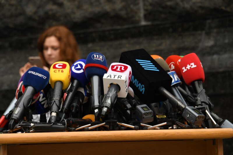 Микрофоны телеканалов и радиостанций на столе перед началом пресс-конференции