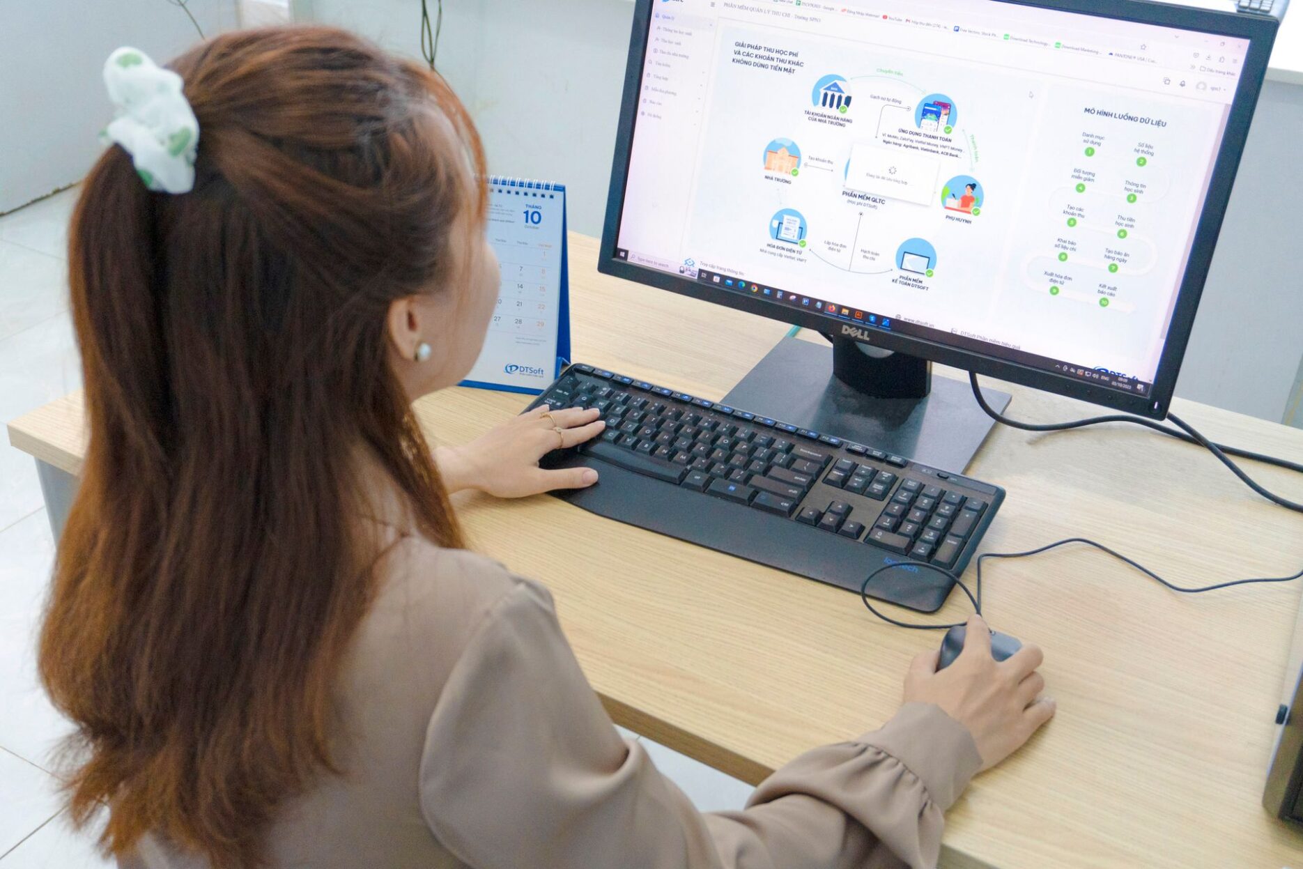 Девушка работает за настольным компьютером в офисе