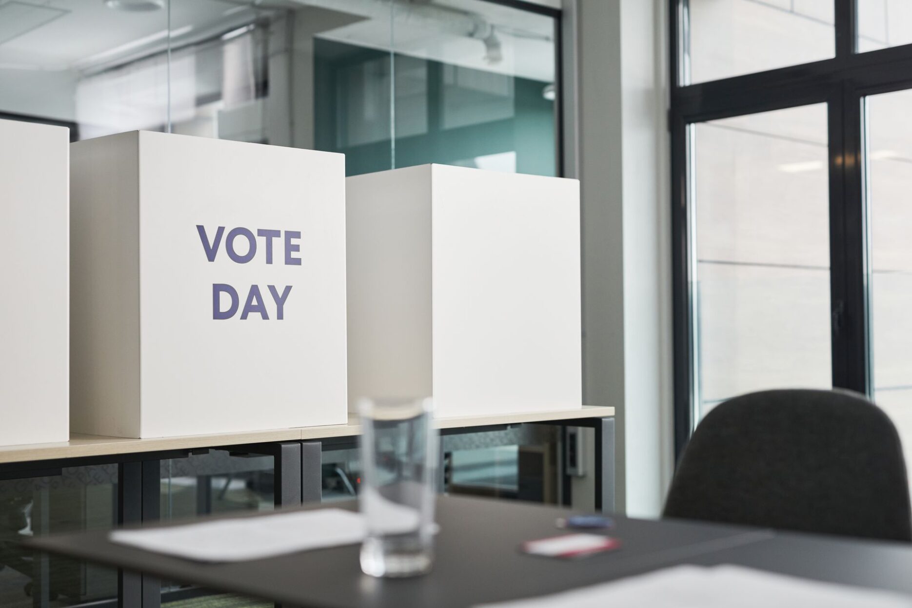Кабинки для голосования с надписью Vote Day на столе в помещении избирательного участка