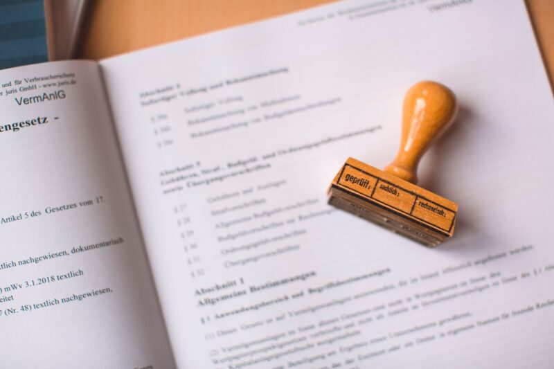Деревянная печать лежит на напечатанном юридическом документе