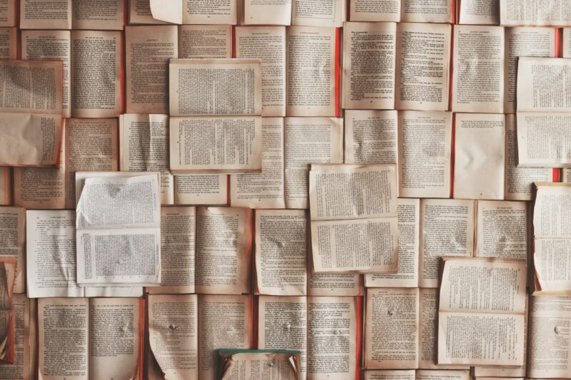 Несколько раскрытых книг, разложенных рядом на столе