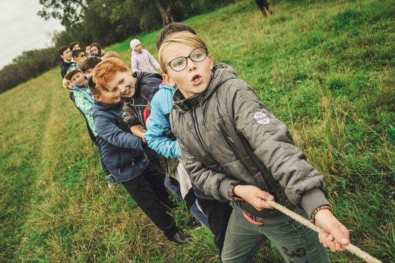 Школьники перетягивают канат во время командной игры на детском фестивале
