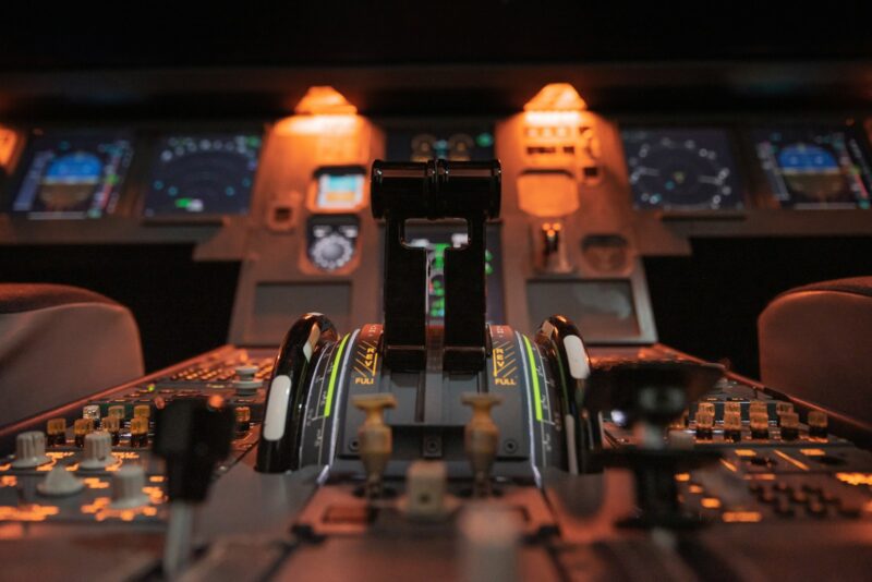 Рычаги управления двигателями на центральном пульте кабины Airbus A320 в подсветке приборной панели