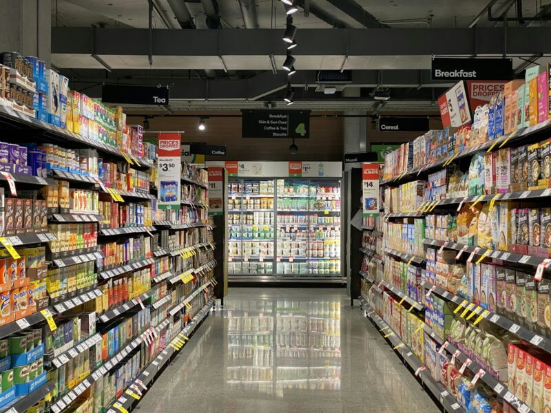 Проход в продуктовом супермаркете: полки заставлены крупами, печеньем, чаем и соусами