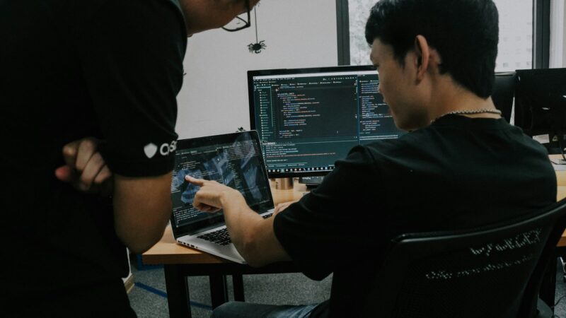 Двое разработчиков работают за компьютерами в офисе