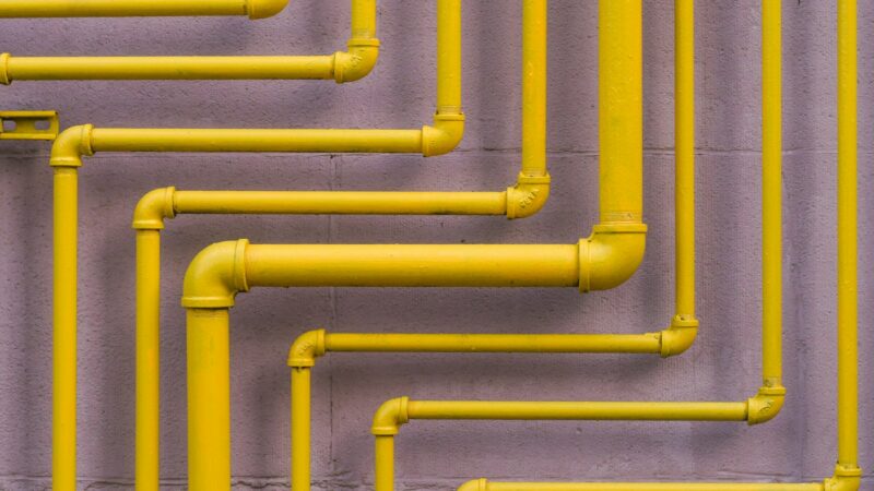Жёлтые газовые трубы, проложенные по стене здания