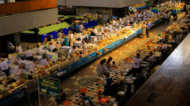 Продавцы и покупатели в торговых рядах рынка в Алматы