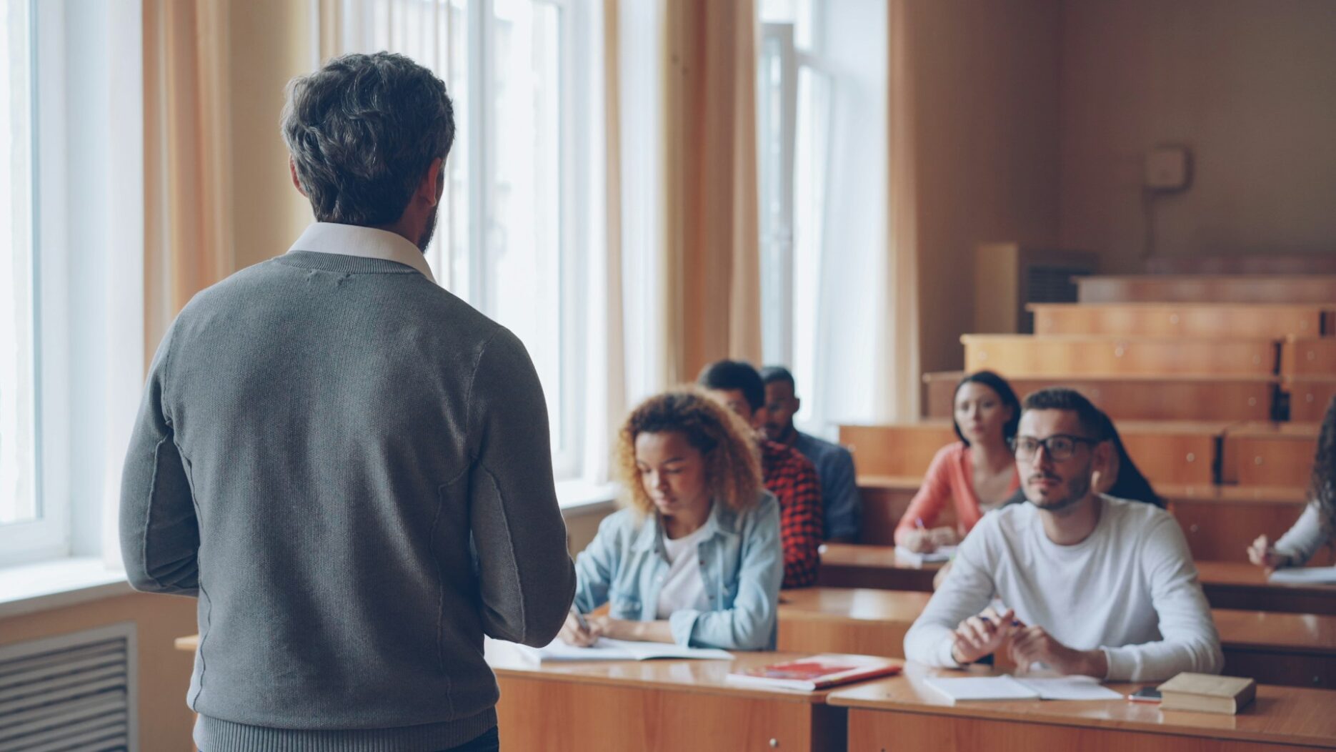 Преподаватель ведёт занятие, студенты слушают в лекционной аудитории университета