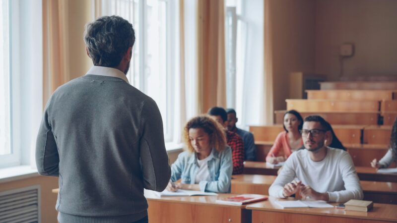 Преподаватель ведёт занятие, студенты слушают в лекционной аудитории университета