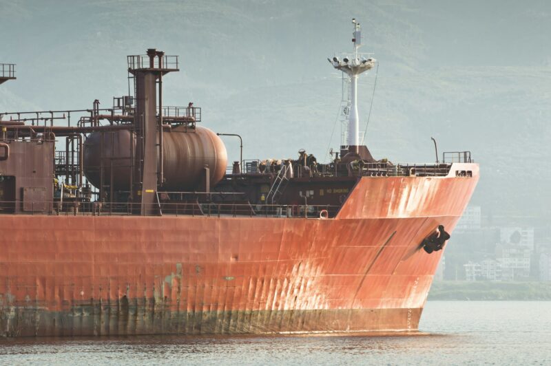 Красное грузовое судно идёт по морю